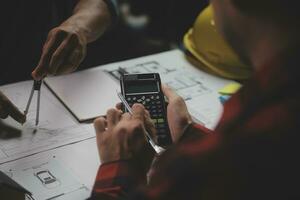 reunión de trabajo en equipo de ingenieros, trabajo de dibujo en la reunión de planos para el trabajo del proyecto con un socio en la construcción de modelos y herramientas de ingeniería en el concepto de sitio de trabajo, construcción y estructura. foto