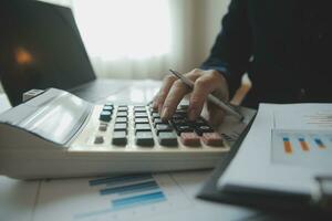 Unrecognizable businessman using calculator photo