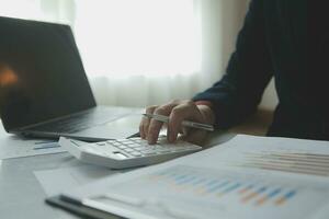 Unrecognizable businessman using calculator photo