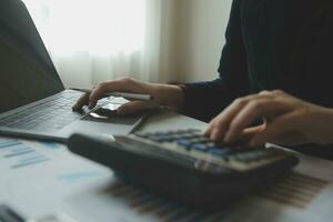 Unrecognizable businessman using calculator photo