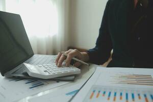 Unrecognizable businessman using calculator photo