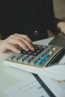Unrecognizable businessman using calculator photo