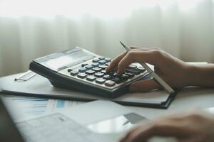 Unrecognizable businessman using calculator photo