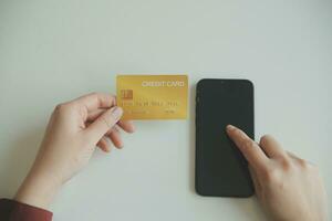 Woman hands holding and using cradit card for shopping online. photo