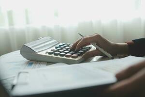 Unrecognizable businessman using calculator photo
