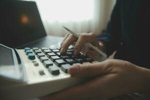 Unrecognizable businessman using calculator photo