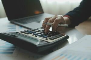 Unrecognizable businessman using calculator photo