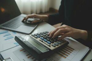 Unrecognizable businessman using calculator photo