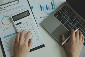 Unrecognizable businessman using calculator photo