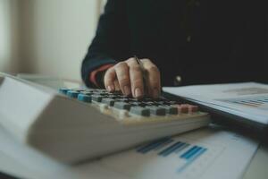 Unrecognizable businessman using calculator photo