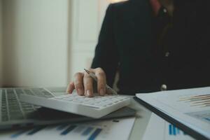 Unrecognizable businessman using calculator photo