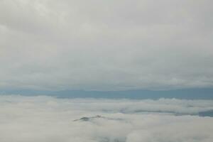 Mountain range with visible silhouettes through the morning blue fog. photo