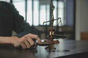 Business and lawyers discussing contract papers with brass scale on desk in office. Law, legal services, advice, justice and law concept picture with film grain effect photo