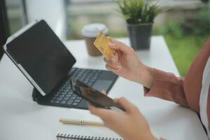 mujer participación crédito tarjeta y utilizando teléfonos inteligentes a casa.online compras, Internet bancario, Tienda en línea, pago, gasto dinero, comercio electrónico pago a el almacenar, crédito tarjeta, concepto foto