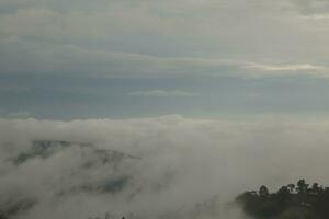 Mountain range with visible silhouettes through the morning blue fog. photo