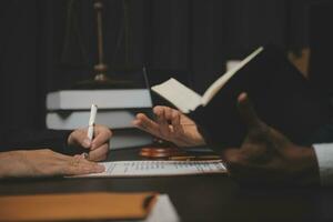 Business and lawyers discussing contract papers with brass scale on desk in office. Law, legal services, advice, justice and law concept picture with film grain effect photo