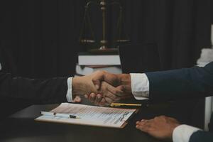 Business and lawyers discussing contract papers with brass scale on desk in office. Law, legal services, advice, justice and law concept picture with film grain effect photo