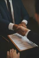 Business and lawyers discussing contract papers with brass scale on desk in office. Law, legal services, advice, justice and law concept picture with film grain effect photo