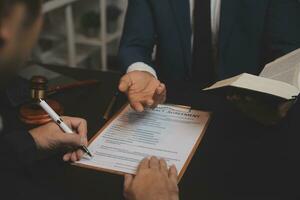 Business and lawyers discussing contract papers with brass scale on desk in office. Law, legal services, advice, justice and law concept picture with film grain effect photo