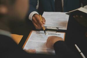 Business and lawyers discussing contract papers with brass scale on desk in office. Law, legal services, advice, justice and law concept picture with film grain effect photo