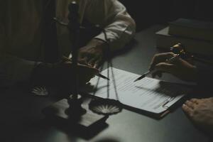 Business and lawyers discussing contract papers with brass scale on desk in office. Law, legal services, advice, justice and law concept picture with film grain effect photo