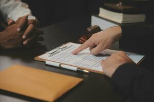 Business and lawyers discussing contract papers with brass scale on desk in office. Law, legal services, advice, justice and law concept picture with film grain effect photo