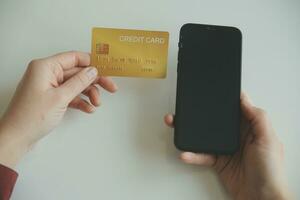 Woman hands holding and using cradit card for shopping online. photo