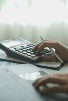 Unrecognizable businessman using calculator photo