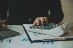 Unrecognizable businessman using calculator photo