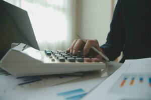 Unrecognizable businessman using calculator photo