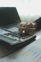 Unrecognizable businessman using calculator photo