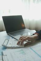 Unrecognizable businessman using calculator photo