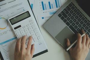 Unrecognizable businessman using calculator photo