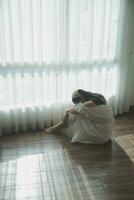 silhouette of woman sitting on the bed beside the windows with sunlight in the morning photo