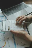 Unrecognizable businessman using calculator photo