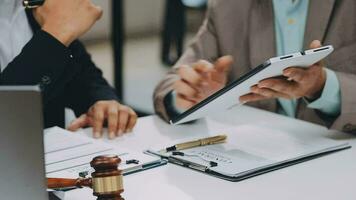 Justice and law concept.Male judge in a courtroom with the gavel, working with, computer and docking keyboard, eyeglasses, on table in morning light video