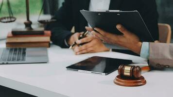 Justice and law concept.Male judge in a courtroom with the gavel, working with, computer and docking keyboard, eyeglasses, on table in morning light video