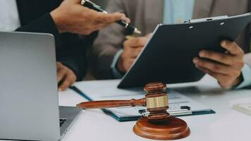 Justice and law concept.Male judge in a courtroom with the gavel, working with, computer and docking keyboard, eyeglasses, on table in morning light video