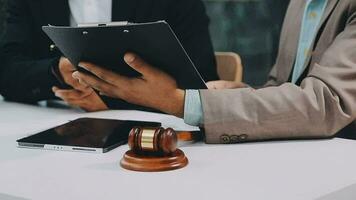 Justice and law concept.Male judge in a courtroom with the gavel, working with, computer and docking keyboard, eyeglasses, on table in morning light video