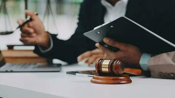 Justice and law concept.Male judge in a courtroom with the gavel, working with, computer and docking keyboard, eyeglasses, on table in morning light video