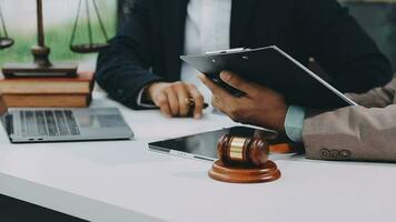 Justice and law concept.Male judge in a courtroom with the gavel, working with, computer and docking keyboard, eyeglasses, on table in morning light video