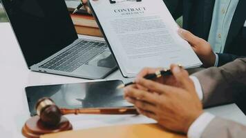 concetto di giustizia e diritto. giudice maschio in un'aula di tribunale con il martelletto, lavorando con computer e tastiera docking, occhiali, sul tavolo alla luce del mattino video