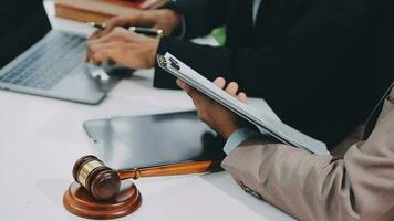 Justice and law concept.Male judge in a courtroom with the gavel, working with, computer and docking keyboard, eyeglasses, on table in morning light video