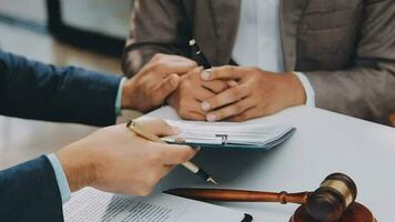 concetto di giustizia e diritto. giudice maschio in un'aula di tribunale con il martelletto, lavorando con computer e tastiera docking, occhiali, sul tavolo alla luce del mattino video