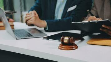 Justice and law concept.Male judge in a courtroom with the gavel, working with, computer and docking keyboard, eyeglasses, on table in morning light video