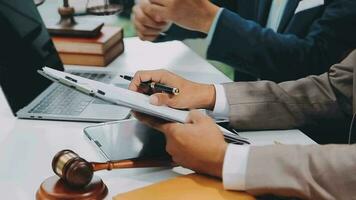 Justice and law concept.Male judge in a courtroom with the gavel, working with, computer and docking keyboard, eyeglasses, on table in morning light video