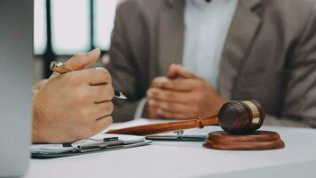 Justice and law concept.Male judge in a courtroom with the gavel, working with, computer and docking keyboard, eyeglasses, on table in morning light video