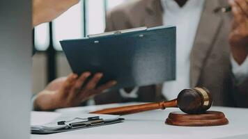 Justice and law concept.Male judge in a courtroom with the gavel, working with, computer and docking keyboard, eyeglasses, on table in morning light video