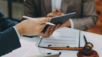 concetto di giustizia e diritto. giudice maschio in un'aula di tribunale con il martelletto, lavorando con computer e tastiera docking, occhiali, sul tavolo alla luce del mattino video