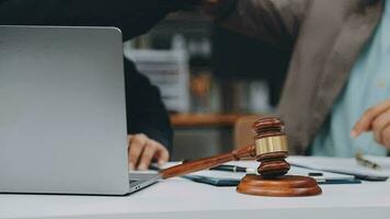 Justice and law concept.Male judge in a courtroom with the gavel, working with, computer and docking keyboard, eyeglasses, on table in morning light video